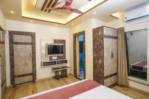 a bedroom with a bed and a flat screen tv at Hotel Sea Wood in Digha