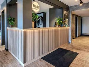 a lobby with a bar with plants on the wall at B&B HOTEL Regensburg-Ost in Regensburg