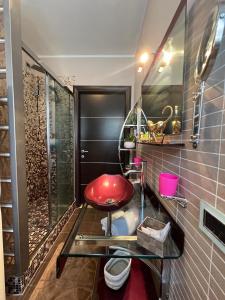 a bathroom with a red stool and a shower at Regina House Vigevano in Vigevano