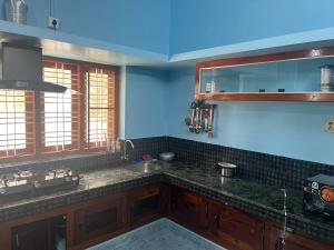 a kitchen with a sink and a counter top at Bright Nest Service Villa Munroe in Kollam