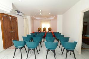 a conference room with blue chairs and a table at Bright Nest Service Villa Munroe in Kollam
