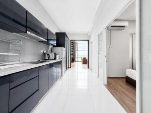 a kitchen with black cabinets and a white floor at Luxury Seaview 2BR Suite Near Georgetown Maritime Penang 0706 in George Town