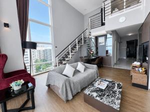 a living room with a couch and a staircase at Luxury Seaview 2BR Suite Near Georgetown Maritime Penang 0706 in George Town