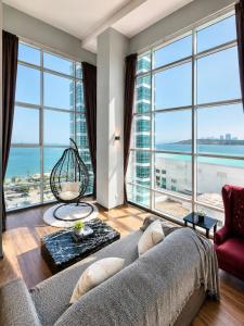 a living room with a couch and large windows at Luxury Seaview 2BR Suite Near Georgetown Maritime Penang 0706 in George Town