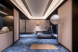 a room with a gym with a treadmill at Orange Crystal Hotel Kunming Haile World in Kunming