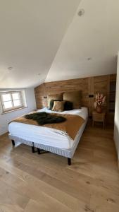 a bedroom with a large bed with a wooden wall at Maison cosy climatisée in Bar-le-Duc