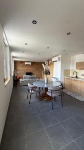 a kitchen and living room with a table and chairs at Maison cosy climatisée in Bar-le-Duc