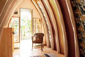 a room with a hallway with a chair and surfboards at Les roulottes de Rita "Le poulailler" in Verfeil-sur-Seye