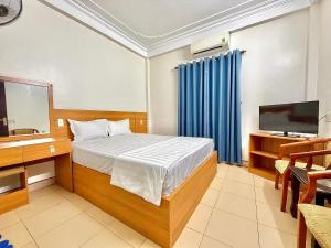 a bedroom with a bed and a tv and a television at Khách sạn Thanh Sơn Nội Bài in Thach Loi