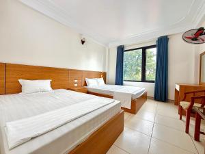 a hotel room with two beds and a window at Khách sạn Thanh Sơn Nội Bài in Thach Loi +5 photos