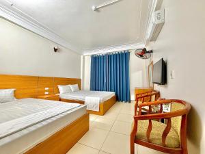 a hotel room with two beds and a chair at Khách sạn Thanh Sơn Nội Bài in Thach Loi
