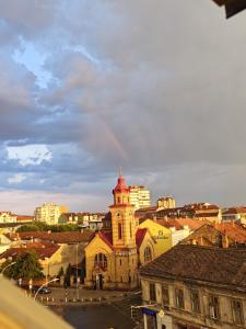 an old building with a clock tower in a city at Apartmani Bajic in Vršac