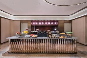 a buffet in a hotel room with food on a counter at Orange Crystal Hotel Kunming Haile World in Kunming +41 photos