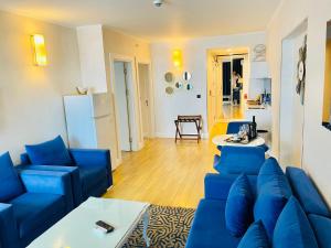 a living room with blue chairs and a blue couch at Batumi High View in Batumi