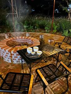 a table with a fire pit on a patio at Hannie House- Mộc Châu in Mộc Châu