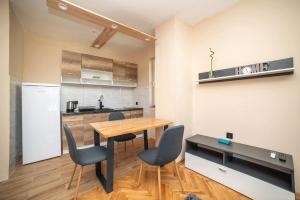 a kitchen with a wooden table and chairs at Apartman Jelena Anžujska in Trebinje