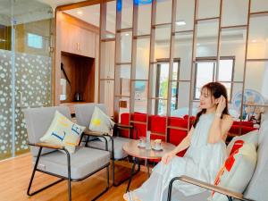 a woman sitting on a couch in a living room at Ánh Sao Sapa Hotel in Sapa +29 photos
