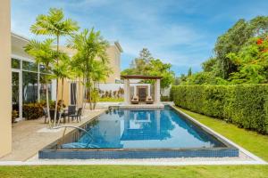a swimming pool in the backyard of a house at Andaman Pool Villas, Maikhao Beach Phuket in Mai Khao Beach