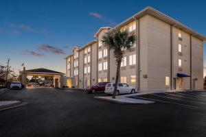 a large building with a palm tree in a parking lot at Comfort Inn & Suites Panama City - St Andrew in Panama City