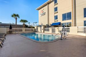 a swimming pool in front of a building at Comfort Inn & Suites Panama City - St Andrew in Panama City