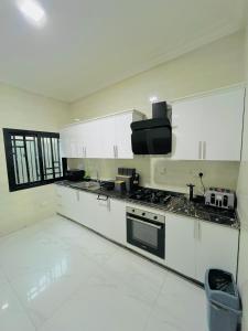 a kitchen with white cabinets and a stove top oven at Yoyo Kunda in Banjul