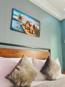 a bedroom with a bed with a picture on the wall at Yoyo Kunda in Banjul +10 photos