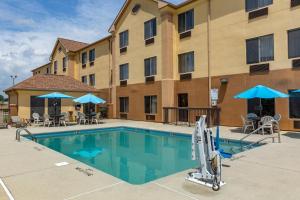 a pool at a hotel with chairs and umbrellas at Comfort Inn Garner Clayton I-40 in Edmondson