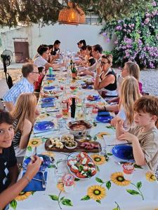 a group of people sitting at a long table with food at Villa Ferranti Abruzzo in Montefino