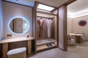 a dressing room with a mirror and a dressing table at Orange Crystal Hotel Kunming Haile World in Kunming