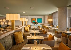 a restaurant with tables and couches and chairs at Adina Sydney Darling Harbour in Sydney