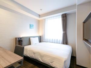 a hotel room with a bed and a window at Comfort Hotel Nagoya Shinkansenguchi in Nagoya