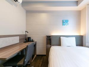 a hotel room with a desk and a bed at Comfort Hotel Nagoya Shinkansenguchi in Nagoya