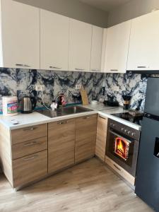 a kitchen with a stove with a fire in it at Cozy Apartment Astiri in Tirana +10 photos