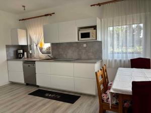 a kitchen with white cabinets and a table and a window at Apartment in Balatonbereny - Balaton 18046 in Balatonberény