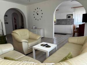 a living room with two couches and a clock on the wall at Apartment in Balatonbereny - Balaton 18046 in Balatonberény +7 photos