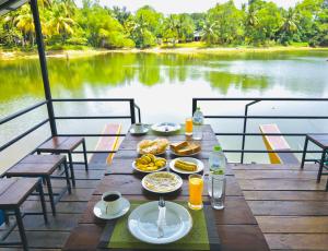 a table with food and drinks on top of a body of water at Splendid Lake View Safari Lodge in Udawalawe