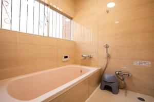 a bathroom with a tub and a toilet and a window at rinne 那須 Garden 3 in Nasu +25 photos