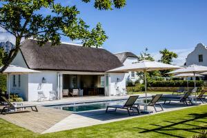 an image of a house with a swimming pool and umbrellas at Brookdale Estate - Manor House in Paarl