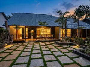 a house with a stone patio in front of it at 1000 SILVERS -Farm Stay in Mysore