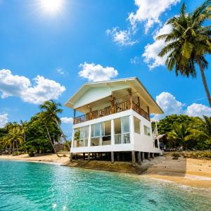 a house on the beach with a palm tree at Beach Terrace Studio - WaveSide Ocean Bliss in Thong Sala