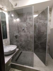 a bathroom with a glass shower and a sink at Magnolia Home Rooms in Toruń