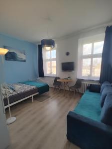 a room with a bed and a couch and a table at Magnolia Home Rooms in Toruń +14 photos