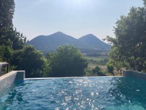 a swimming pool with mountains in the background at Home in Drome provençale in Vesc
