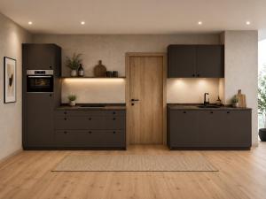 a kitchen with black cabinets and a wooden floor at Alpine Residence by alpenappartements in Mayrhofen