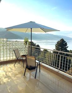 a patio with a table and chairs and an umbrella at Lake View Apartment in Pogradec