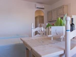 a table with a glass of wine and a bed at Le Residence del Golfo Orosei in Orosei