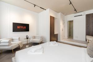 a bedroom with a bed and two chairs and a mirror at La Maison Parliament by BQA in Budapest
