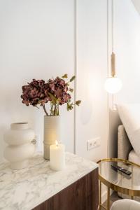 a table with a candle and a vase with flowers at La Maison Parliament by BQA in Budapest +50 photos