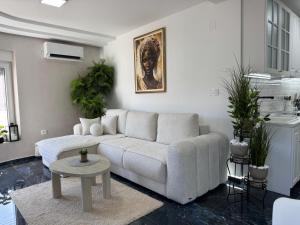 a living room with a white couch and a table at Angel Luxury Apartment in Kikinda