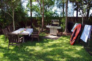 a backyard with a picnic table and a grill at Emeraldene Inn & Eco-Lodge in Hervey Bay